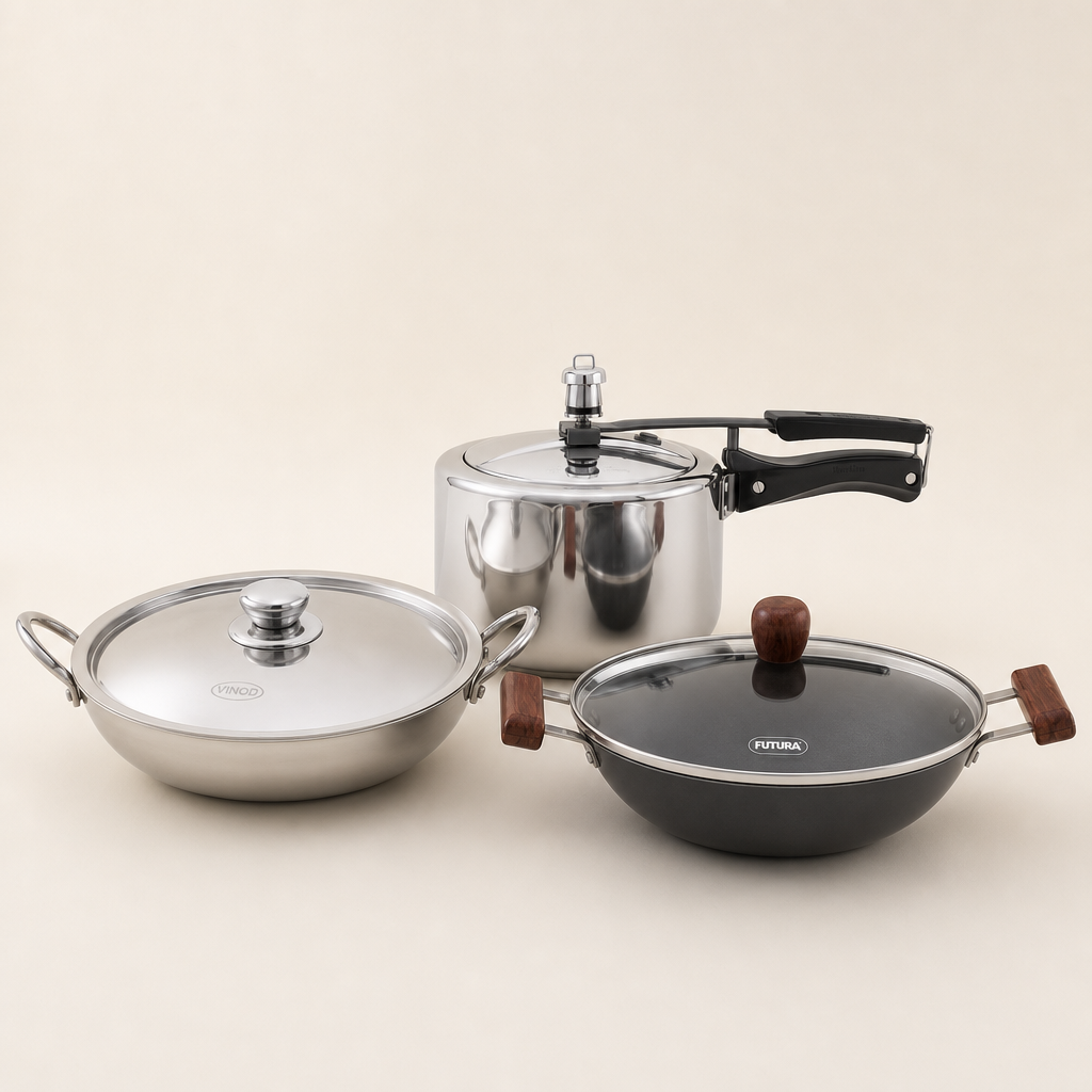 Studio photograph of Vinod triply kadai, Hawkins stainless steel pressure cooker and Futura deep fry pan